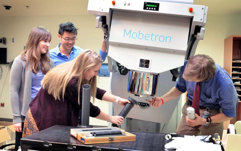 Katherine Hand and students explore how mobetron (electron-beam linear accelerator) machine works